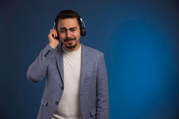 Male dj in grey suit listening to headphones and gets touched. 