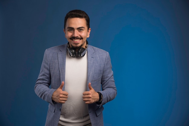 Free photo male dj in grey suit with headphones in the neck.