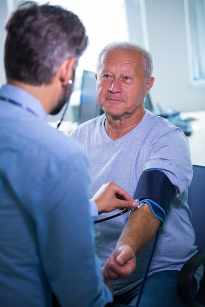 Male doctor checking blood pressure of patient