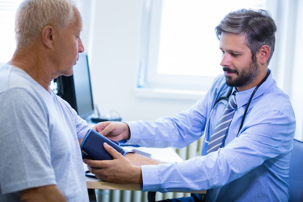 Male doctor checking blood pressure of patient