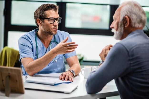 Male doctor communicating with senior patient during medical consultations at his office