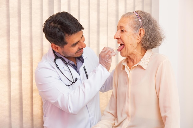 Male doctor examining elderly woman's throat in consultation. doctor checking old woman's throat