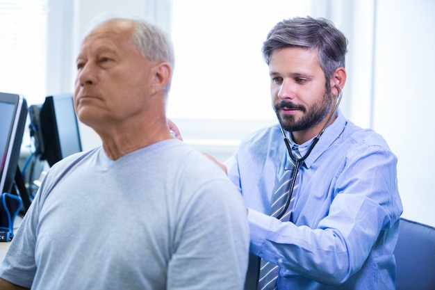 Free photo male doctor examining a patient