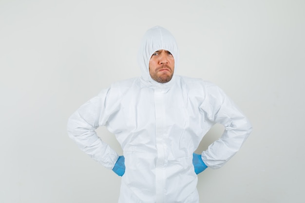 Male doctor holding hands on waist in protective suit