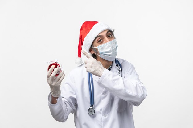 Male doctor holding New Year tree toy desk health covid virus