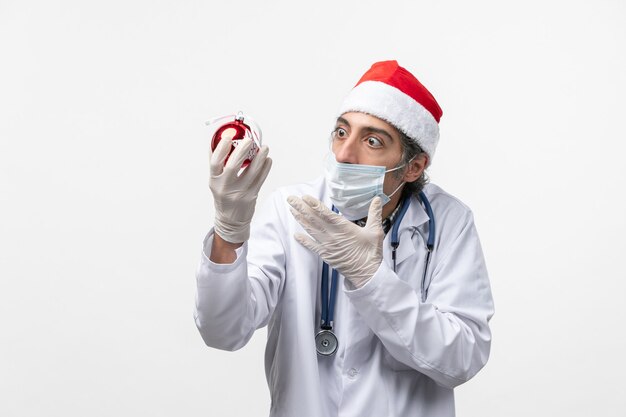 Мужчина-врач, держащий новогоднюю елку, игрушечный стол, вирус здоровья covid