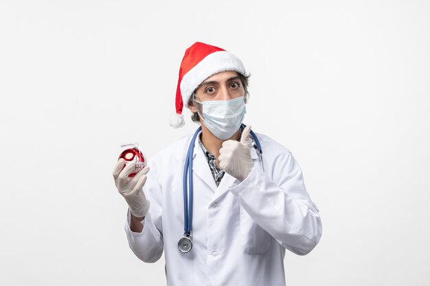 Male doctor holding New Year tree toy virus covid