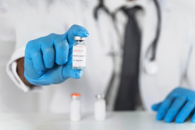 Male doctor holding a vaccine recipient close-up