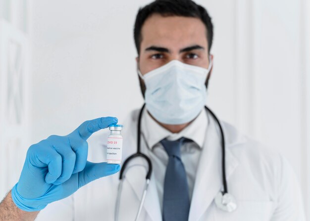 Male doctor holding a vaccine recipient