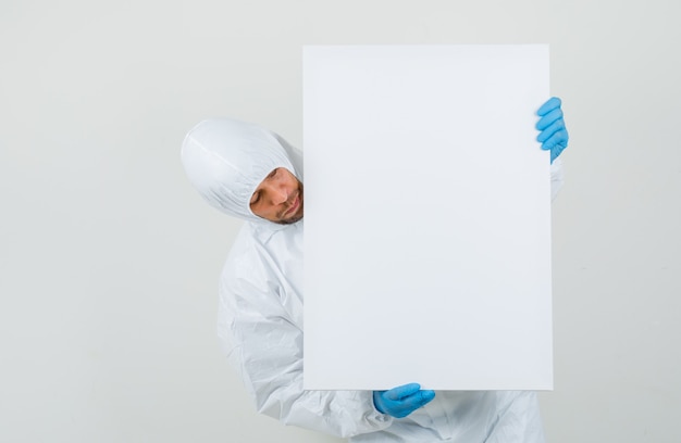 Male doctor looking at white board in protective suit