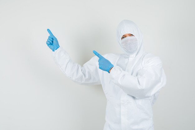 Male doctor pointing to the side with fingers up in protective suit