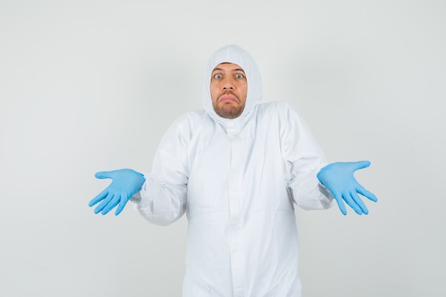 Male doctor showing helpless gesture in protective suit