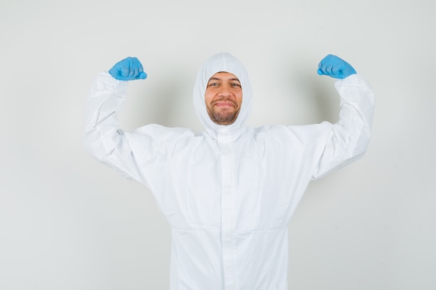 Male doctor showing muscles of arms in protective suit