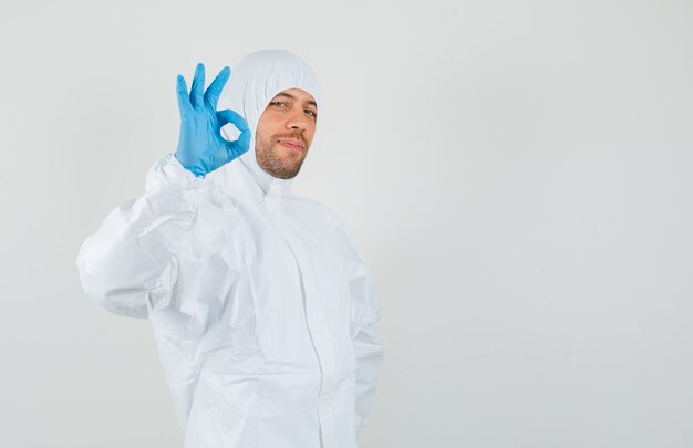 Male doctor showing ok gesture in protective suit