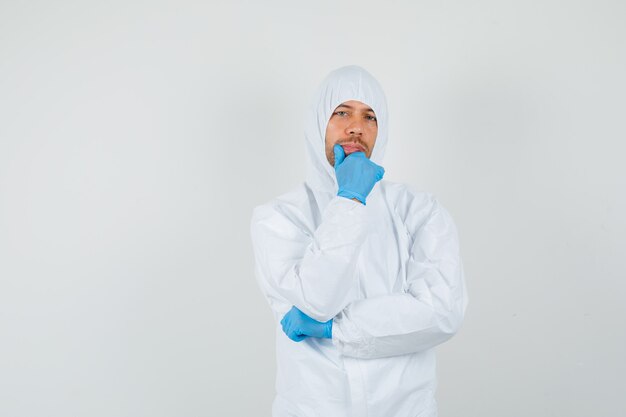 Male doctor standing in thinking pose in protective suit