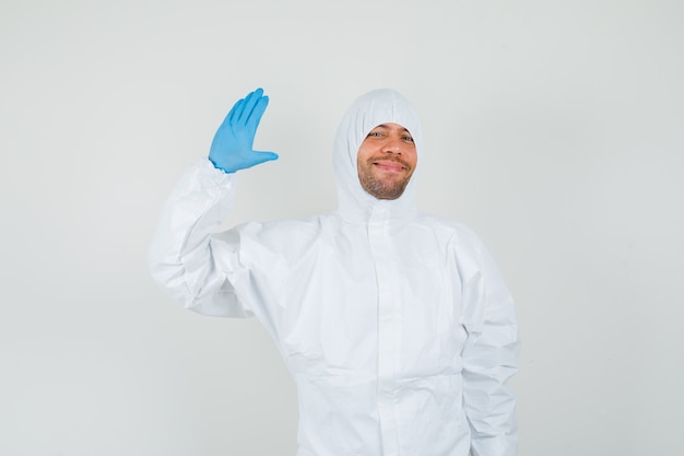 Foto gratuita medico maschio agitando la mano per il saluto in tuta protettiva