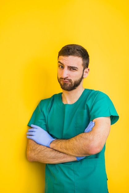 Free photo male doctor with crossed arms raising eyebrow