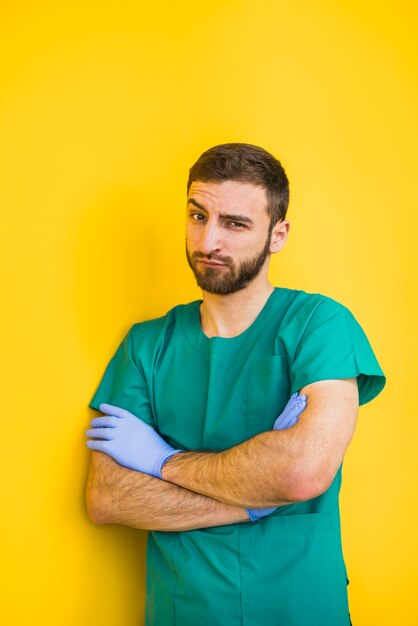 Male doctor with crossed arms raising eyebrow