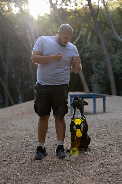 Male dog trainer outdoors with dog during session