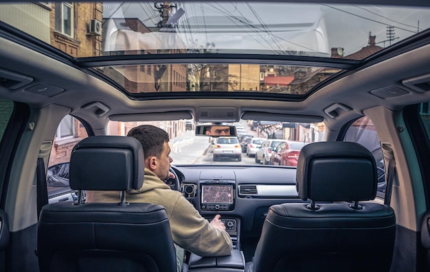 A male driver drives at speed through the streets of the city