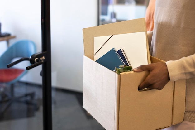 Male employee exploring his new new office job location while carrying box of belongings