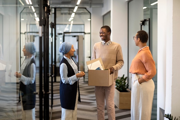 Male employee exploring his new new office job location while carrying box of belongings