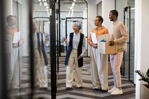 Male employee exploring his new new office job location while carrying box of belongings