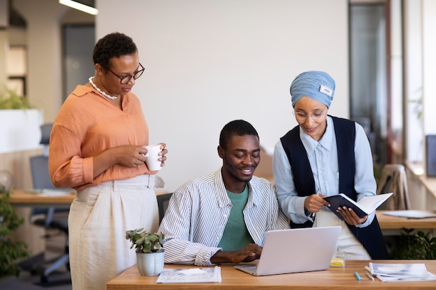 Foto gratuita impiegato maschio che si abitua al suo nuovo lavoro d'ufficio insieme alle colleghe