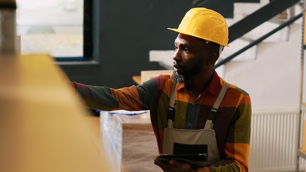 Free photo male employee scanning barcodes with scanner, inspecting stock logistics and order delivery. african american man reviewing supply chain and distribution, retail shipping. handheld shot.