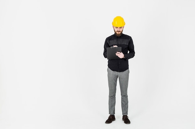 Male engineer writing on clipboard over white background