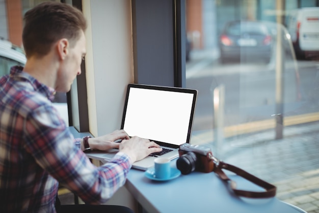 Free photo male executive using laptop at counter