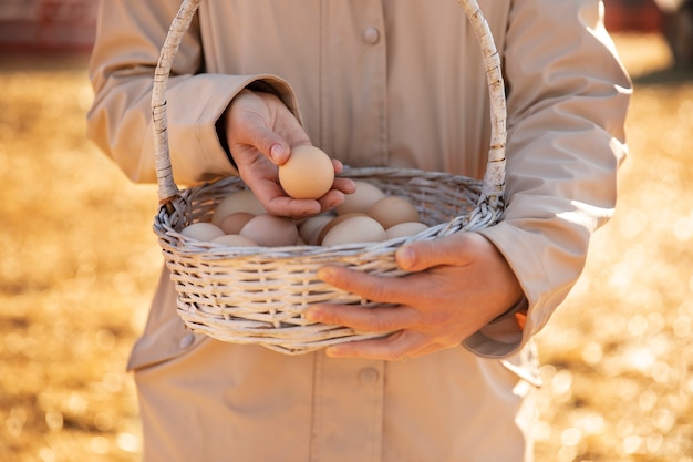 그의 농장에서 계란 바구니를 들고 남성 농부