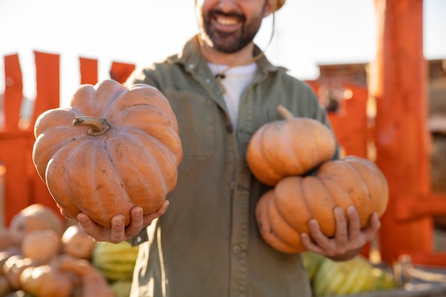 Male farmer holding pumpkin harvest at the farm