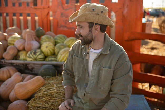 Male farmer with the harvest of pumpkins and watermelons at his farm