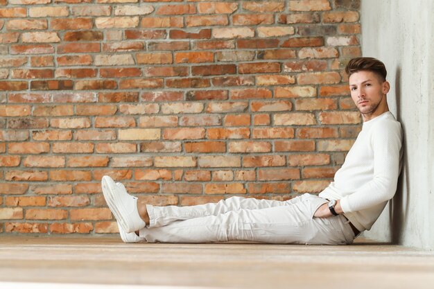 Мужская мода на деревянном полу, молодой человек позирует