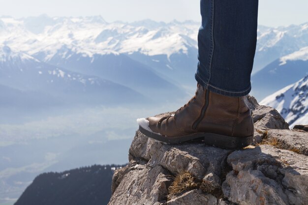 Male feet on edge of wooden bench. 