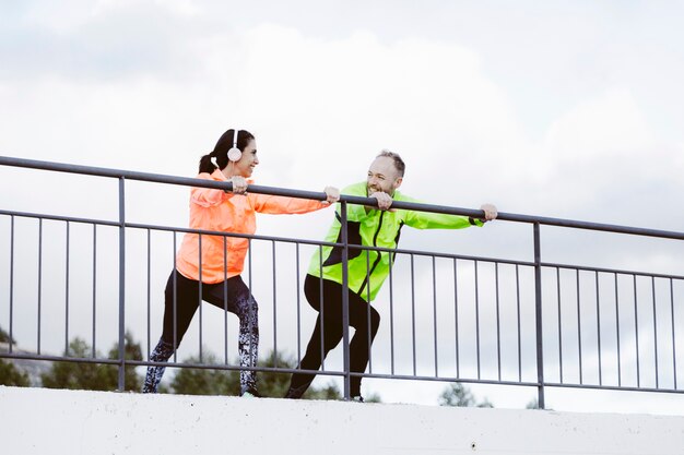 Male and female athlete stretching outdoors