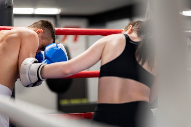 Male and female boxers confronting each other in the ring