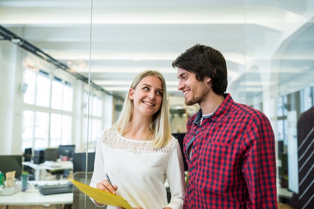 Male and female business executive interacting over a document