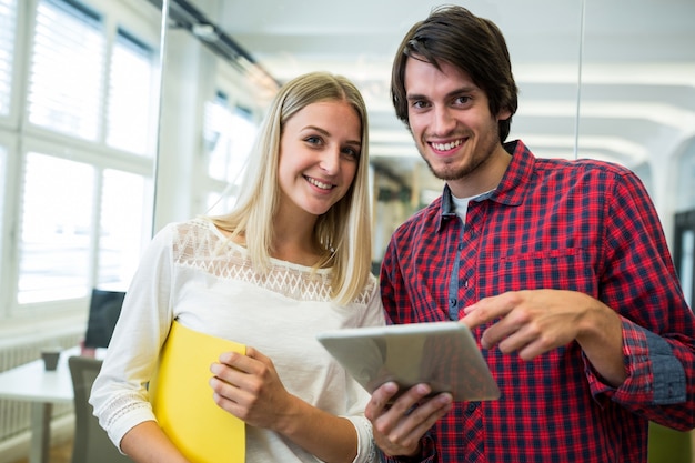 Male and female business executives using digital tablet