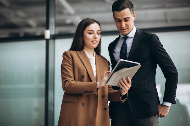 male and female business people working on tablet in office