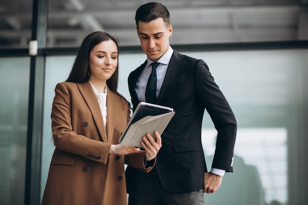 Male and female business people working on tablet in office