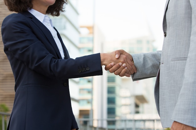 Male and female colleagues greeting each other in city