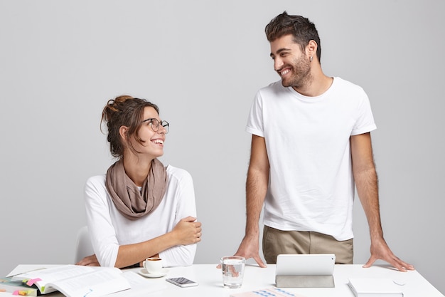 Male and female coworkers near desk