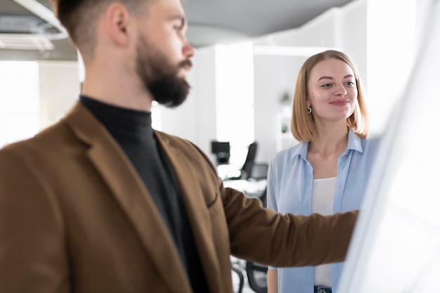 Free photo male and female coworkers in the same room