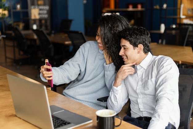 Free photo male and female coworkers smiling while having a video call