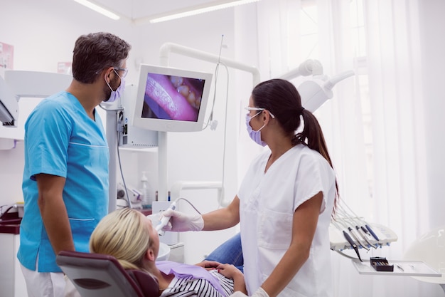 Male and female dentist examining patient