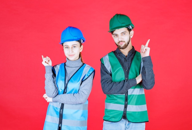 Male and female engineers wearing helmet and gear showing up.