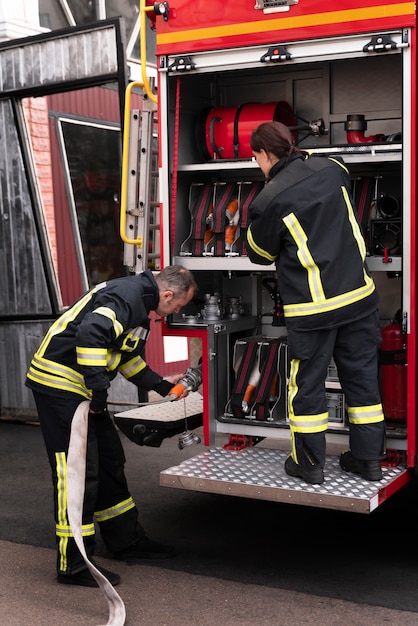 Free photo male and female firefighters at the station working together