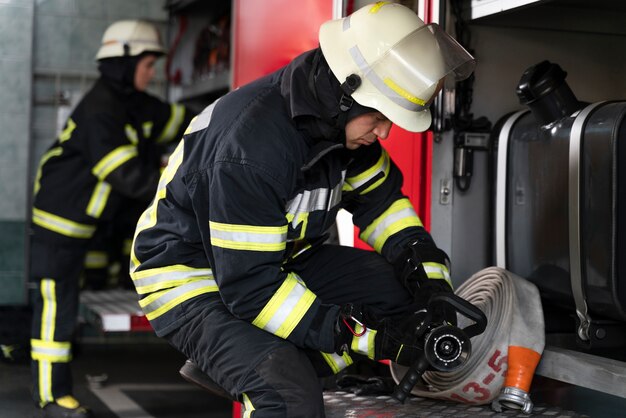 Male and female firefighters working together in suits and helmets